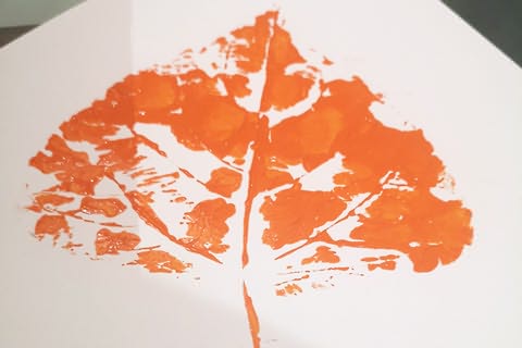 Folha de papel com impressão de folha de árvore em tinta laranja