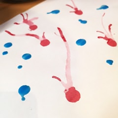 Uma folha de papel com gotas e sulcos de tinta colorida