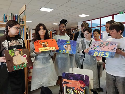 Vários alunos em pé segurando à sua frente as placas pintadas