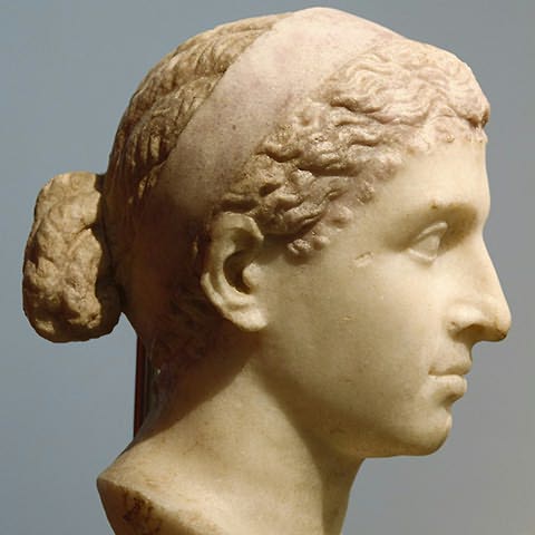 (Busto) Mulher de cabelo apanhado e faixa no cabelo