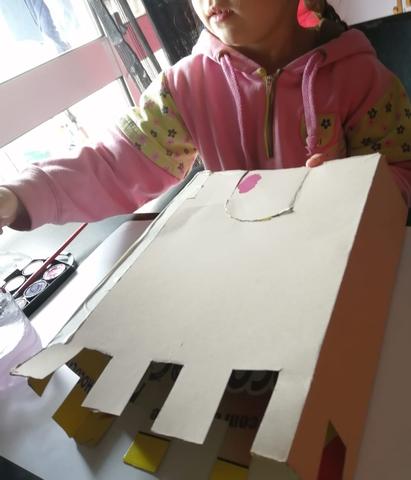 Menina a pintar caixa de cartão recortada com aguarelas