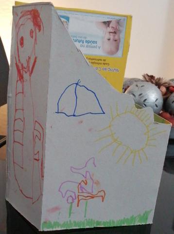 Caixa arquivadora com desenhos a marcador por fora (interior amarelo com fotografia de bebé e texto