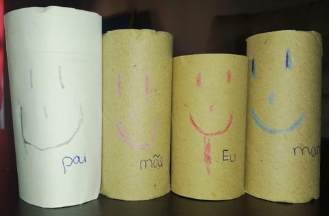 Membros da família desenhados e coloridos com lápis de cera em rolos de papel higiénico