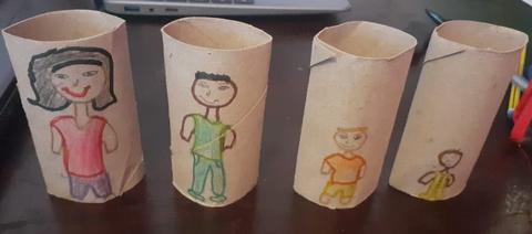 Membros da família desenhados e coloridos com canetas de feltro e lápis de cor em rolos de papel higiénico