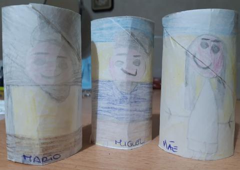 Membros da família desenhados e coloridos com lápis de cor em rolos de papel higiénico