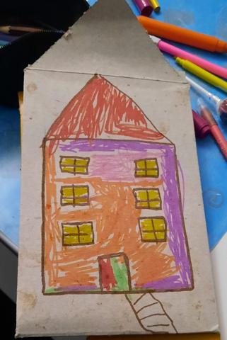 Casa desenhada e colorida com canetas de feltro numa base de cartão